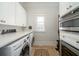 Bright laundry room with white cabinets, front load washer and dryer, and tile flooring at 1905 Lone Oak Pt, Mount Pleasant, SC 29466