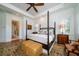 Bright main bedroom with four-poster bed, wood floors, sitting area, and natural light at 1905 Lone Oak Pt, Mount Pleasant, SC 29466