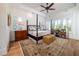 Serene bedroom featuring a four-poster bed, tray ceiling, and natural light from shuttered windows at 1905 Lone Oak Pt, Mount Pleasant, SC 29466