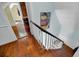 A hallway showing hardwood floors, white railing, and a vintage racing poster at 197 Coming St, Charleston, SC 29403