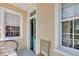 A porch with neutral colored walls and a blue front door flanked by two windows at 197 Coming St, Charleston, SC 29403