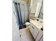 Bathroom with a blue shower curtain, white vanity and cabinet, and neutral tile flooring at 2040 Rondo St # H, Charleston, SC 29414