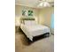 Comfortable bedroom with neutral walls, white bedding, and leafy green decorative wall art at 2040 Rondo St # H, Charleston, SC 29414