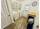 Bright laundry room with washer, dryer, cabinets, and vinyl plank flooring at 2040 Rondo St # H, Charleston, SC 29414