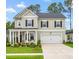 Charming two-story home with manicured lawn, dark shutters, and a two-car garage at 206 Red Bluff St, Summerville, SC 29483