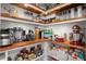 Organized pantry with wooden shelving featuring a variety of food items and small kitchen appliances at 206 Red Bluff St, Summerville, SC 29483