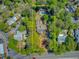 Aerial view showcases the expansive property with lush trees, sparkling pool, and charming apartment at 207 Central Ave, Summerville, SC 29483
