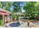 Beautiful backyard with a patio, seating area, lush landscaping, and a glimpse of a pool at 207 Central Ave, Summerville, SC 29483