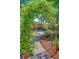 Lush backyard with a pergola overlooking a pool, surrounded by greenery and landscaping at 207 Central Ave, Summerville, SC 29483