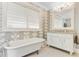 Classic bathroom with clawfoot tub, white vanity, and patterned wallpaper at 207 Central Ave, Summerville, SC 29483