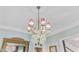 Close-up of elegant crystal chandelier with red shades and ornate ceiling molding at 207 Central Ave, Summerville, SC 29483