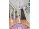 Elegant foyer featuring hardwood floors, grand staircase, and decorative chandelier at 207 Central Ave, Summerville, SC 29483