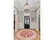 Charming entryway features a decorative chandelier, hardwood floors, and a colorful round rug at 207 Central Ave, Summerville, SC 29483