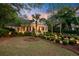 Brick home featuring landscaped yard, palm trees, and inviting curb appeal at dusk at 207 Central Ave, Summerville, SC 29483