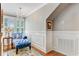 Bright hallway featuring hardwood floors, a tufted chaise lounge, and natural light from the shuttered windows at 207 Central Ave, Summerville, SC 29483