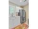 Charming kitchen with white cabinets, stainless steel refrigerator, and colorful rug at 207 Central Ave, Summerville, SC 29483