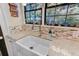 Close up of modern kitchen sink with granite counters, mosaic backsplash and a bright view at 207 Central Ave, Summerville, SC 29483