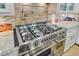Modern kitchen stove with stainless steel range hood, custom backsplash, and granite counters at 207 Central Ave, Summerville, SC 29483