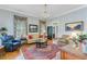 Elegant living room with hardwood floors, chandelier, plantation shutters and designer drapes at 207 Central Ave, Summerville, SC 29483