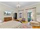 Bright primary bedroom featuring hardwood floors, a chandelier, and patio access at 207 Central Ave, Summerville, SC 29483