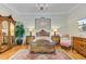Elegantly appointed primary bedroom with hardwood floors, a chandelier, and classic furnishings at 207 Central Ave, Summerville, SC 29483