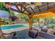 Covered outdoor living with a ceiling fan overlooking the pool and lush backyard at 207 Central Ave, Summerville, SC 29483