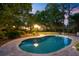 Evening view of backyard pool and outdoor lighting with a charming home in the background at 207 Central Ave, Summerville, SC 29483