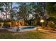 Backyard with a private pool, pergola, lush landscaping, and brick patio perfect for relaxing at 207 Central Ave, Summerville, SC 29483