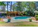Inviting pool area with a covered lounge area and a sun deck, surrounded by mature trees at 207 Central Ave, Summerville, SC 29483