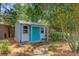 A backyard shed with a blue door, surrounded by lush trees at 207 Central Ave, Summerville, SC 29483