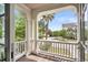 Balcony with white columns and railings, offering picturesque views of the lush landscape and nearby community at 21 Morgan Place Dr, Isle of Palms, SC 29451