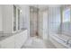 Elegant bathroom featuring a marble countertop vanity, glass-enclosed shower, and soaking tub with striped wallpaper at 21 Morgan Place Dr, Isle of Palms, SC 29451