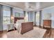 Bright bedroom with hardwood floors, plush rug, light blue walls, and ample natural light from multiple windows at 21 Morgan Place Dr, Isle of Palms, SC 29451