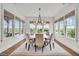 Bright dining room with many windows offers natural light and a beautiful chandelier at 21 Morgan Place Dr, Isle of Palms, SC 29451