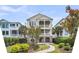 Charming two-story home with inviting double porches, lush landscaping, and a quaint brick walkway at 21 Morgan Place Dr, Isle of Palms, SC 29451