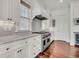 Gourmet kitchen features a stainless steel range, custom cabinets, stone countertops, and hardwood floors at 21 Morgan Place Dr, Isle of Palms, SC 29451
