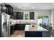Open kitchen boasts dark cabinets, granite countertops, and stainless steel appliances at 210 Grand Palm Ln, Summerville, SC 29485