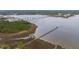 An aerial view reveals a waterfront community with a long pier, marina, bridges, and lush natural surroundings at 2282 Braided Ln, Mount Pleasant, SC 29466