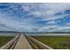 A picturesque wooden dock extends over the tranquil water, inviting residents to enjoy serene views and waterfront activities at 2282 Braided Ln, Mount Pleasant, SC 29466