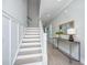 Well-lit staircase with white risers and handrail, complemented by stylish gray walls and hardwood floors at 2282 Braided Ln, Mount Pleasant, SC 29466