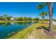 Picturesque waterfront view featuring a serene pond, swaying palms, and lush landscaping at 2302 Hamlin Sound Cir, Mount Pleasant, SC 29466