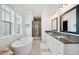 Bright bathroom featuring a soaking tub, dual vanities with granite countertops, and a glass-enclosed shower at 2568 Helmsman Rd, Johns Island, SC 29455