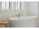 Close-up of a luxurious soaking tub with elegant fixtures and natural light from a nearby window at 2568 Helmsman Rd, Johns Island, SC 29455