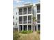Three-story home features screened porches, lush landscaping, and beach access at 2568 Helmsman Rd, Johns Island, SC 29455