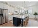 An open concept kitchen featuring white cabinets, stainless appliances, and a large center island with seating at 2568 Helmsman Rd, Johns Island, SC 29455