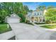 Beautiful two-story home with a detached garage, long driveway, and inviting front porch with chairs and landscaping at 2668 Private Lefler Dr, Johns Island, SC 29455