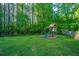 A charming backyard playground with a swing set and slide, nestled among lush greenery and mature trees at 2668 Private Lefler Dr, Johns Island, SC 29455