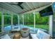 Relaxing screened porch boasts modern furnishings, a stylish fire pit, and views of the lush backyard at 2668 Private Lefler Dr, Johns Island, SC 29455