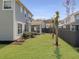 Backyard featuring lush green grass, well-placed palm trees, and a charming screened-in porch for outdoor relaxation at 2889 Backman St, Mount Pleasant, SC 29466