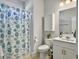 Cozy bathroom featuring a shower with a blue floral curtain, toilet, vanity, and a small storage cabinet at 2889 Backman St, Mount Pleasant, SC 29466